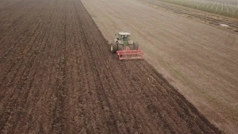 Tractor plows a field, aerial view Stock Footage 129589230