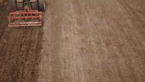 Tractor plows a field, aerial view Stock Footage 129880650