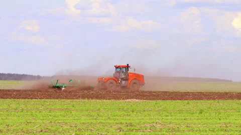 A tractor plows a field, a farmer prepares for sowing for work, growing Vídeo Stock 197672841