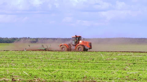 A tractor plows a field, a farmer prepares for sowing for work, growing Vídeo Stock 201001159