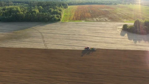 Tractor Plows Field Or Plants Seeds In Spring Against The Sun Rays At Sunset Stock Footage 122236136