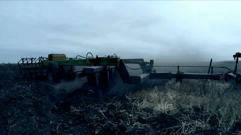 Tractor plows the field with a plow in the evening Stock-Footage 85890097