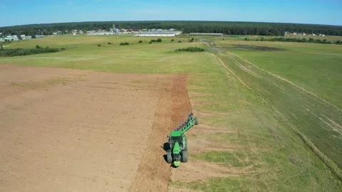 Tractor plows the field by plow, plowing fields. Farmer preparing the soil for Video stock 144059074