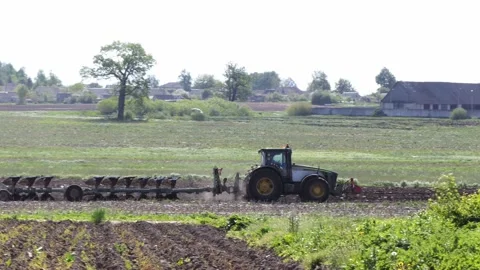 Tractor plows the field. side view of a large tractor at work Video stock 203971058