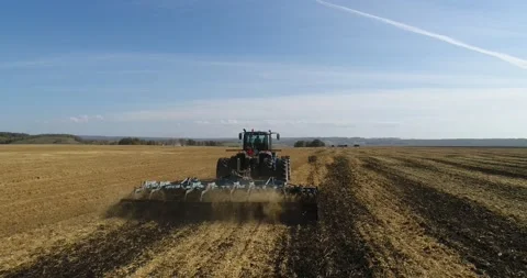 The tractor plows the field for sowing wheat. A beautiful new tractor. Stock Footage 139623264