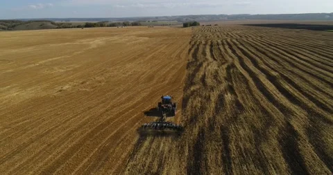 The tractor plows the field for sowing wheat. A beautiful new tractor. Stock Footage 139624108