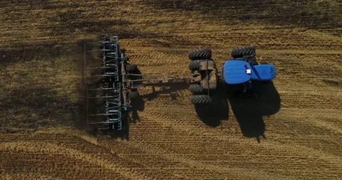 The tractor plows the field for sowing wheat. A beautiful new tractor. Stock Footage 139624120