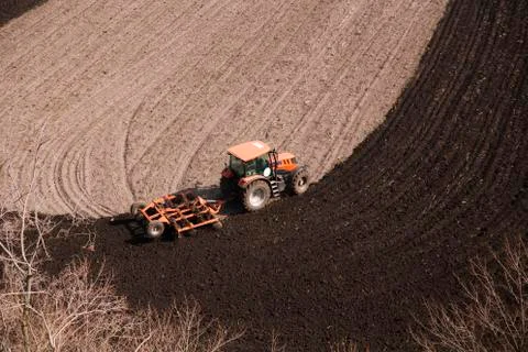 Tractor plows a field in the spring accompanied by rooks Tractor Stock Photos