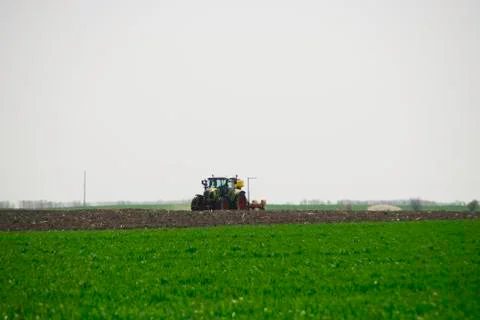 Tractor plows a field in the spring Stock Photos