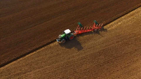 Tractor plows a field in spring -Tractor cultivating a field - Aerial view Stock Footage 88498927