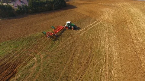 Tractor plows a field in spring -Tractor cultivating a field  - Aerial view Stock Footage 88500726