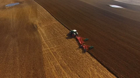 Tractor plows a field in spring -Tractor cultivating a field  - Aerial view Stock Footage 88502712