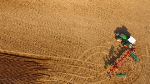 Tractor plows a field in spring -Tractor cultivating a field - Aerial view Stock Footage 88503497