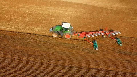 Tractor plows a field in spring -Tractor cultivating a field - Aerial view Stock Footage 88504819