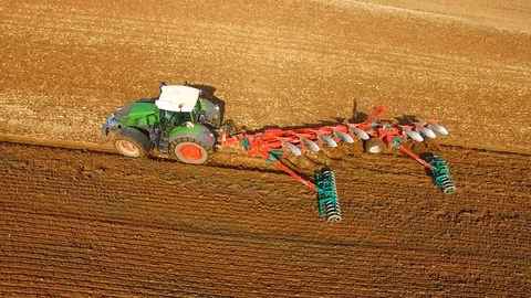 Tractor plows a field in spring -Tractor cultivating a field - Aerial view Stock Footage 88504958