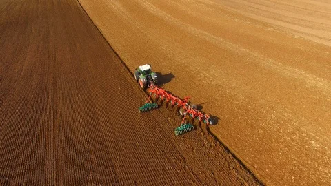 Tractor plows a field in spring -Tractor cultivating a field - Aerial view Stock Footage 88505231