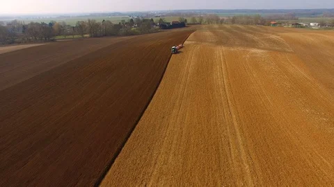 Tractor plows a field in spring -Tractor cultivating a field - Aerial view Stock Footage 88505908