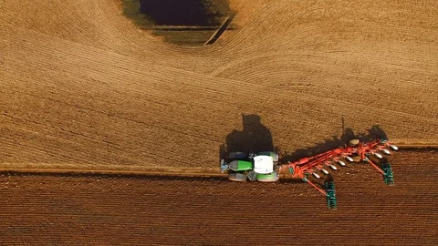 Tractor plows a field in spring -Tractor cultivating a field - Aerial view Stock Footage 88518061