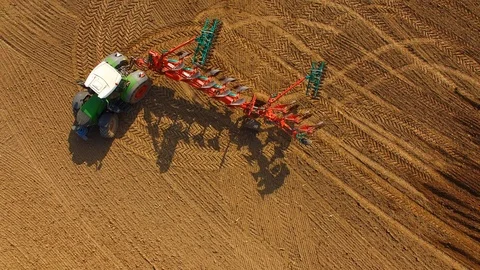 Tractor plows a field in spring -Tractor cultivating a field - Aerial view Stock Footage 88518237