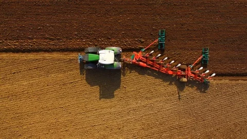 Tractor plows a field in spring -Tractor cultivating a field - Aerial view Stock Footage 88518457