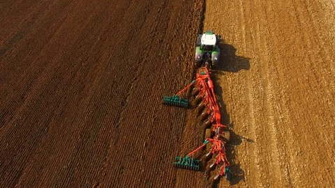 Tractor plows a field in spring -Tractor cultivating a field - Aerial view Stock Footage 88518684