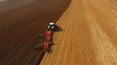 Tractor plows a field in spring -Tractor cultivating a field - Aerial view Stock Footage 88518750