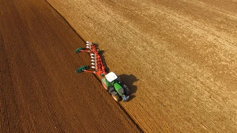 Tractor plows a field in spring -Tractor cultivating a field - Aerial view Stock Footage 88520118