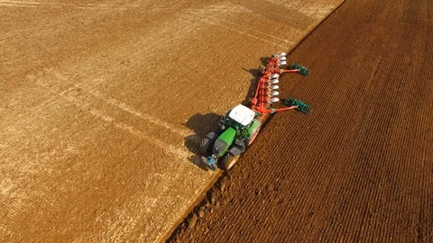 Tractor plows a field in spring -Tractor cultivating a field - Aerial view Stock Footage 88520140
