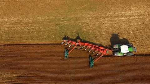 Tractor plows a field in spring -Tractor cultivating a field - Aerial view Stock Footage 88520765