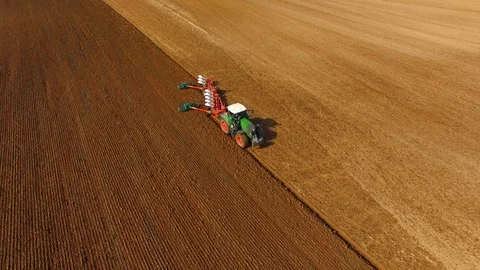 Tractor plows a field in spring -Tractor cultivating a field - Aerial view Stock Footage 88522491
