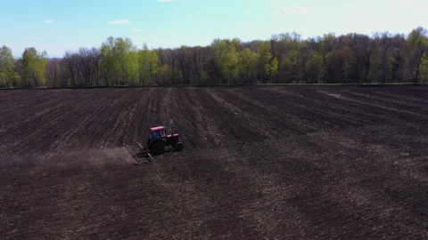 Tractor plows the field in spring. A tractor with a system of disc harrows plows Stock Footage 200198263