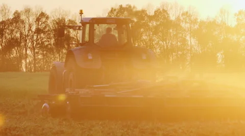 Tractor plows a field at sunset Stock Footage 62859181