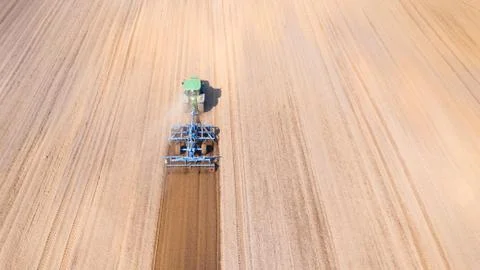 Tractor plows the field, top view. The agricultural field is prepared for Stock Photos