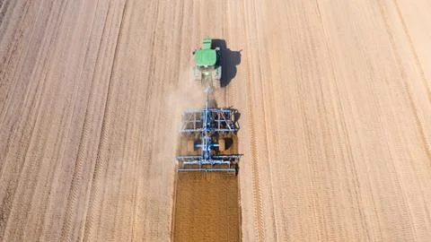 Tractor plows the field, top view. The agricultural field is prepared for Stock Photos