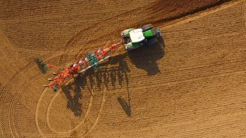 Tractor plows a field - Tractor cultivating a field in spring - Aerial view Stock Footage 88498717