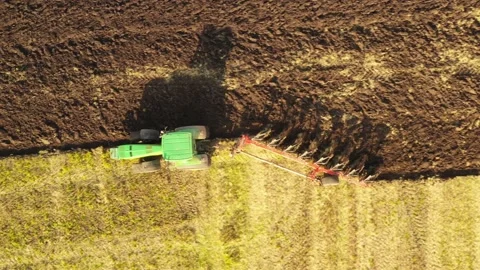 The tractor plows the field. Vertical view from a drone. Stock Footage 148038948
