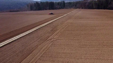 Tractor plows fields on a hill, top view Stock Footage 172378443