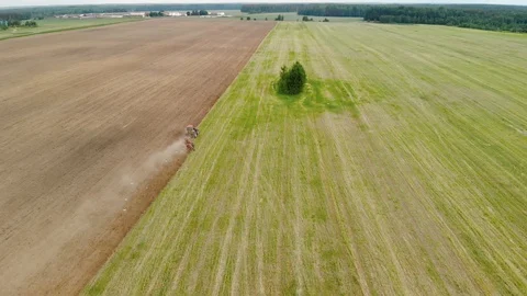 Tractor plows fields in the spring. Beautiful landscape from above Vídeos de archivo 117591383