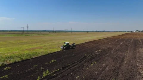 A tractor plows a green field Stock Footage 289300233