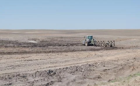 The tractor plows the ground. Spring field work. Preparation for sowing agric Foto stock