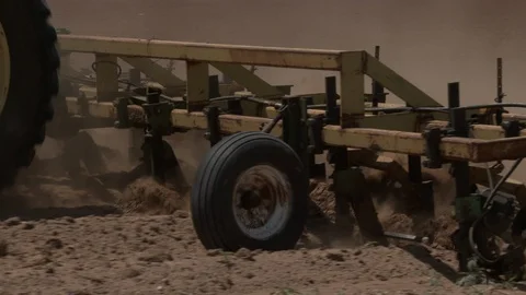 Tractor with plows passes camera raising lot's of dust, 4K. Stock Footage 100045550