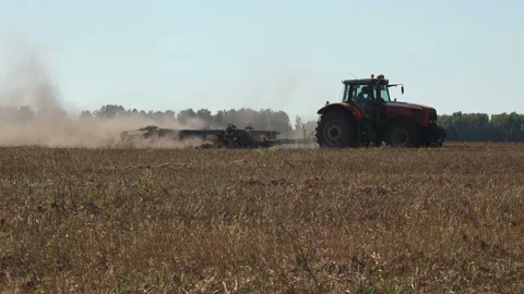 Tractor plows the seeder with dry black soil, does wheat on a large agricultural Stock Footage 142227922