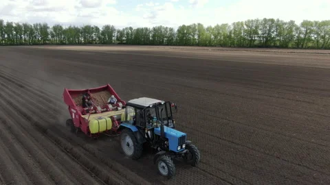 Tractor with potato planter in the field Видео 236835517
