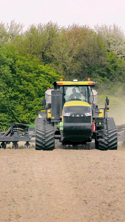 Tractor Preparing Field for Planting, A large tractor equipped with farming Stock Footage 317896720