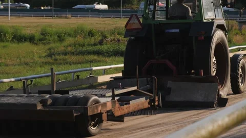 Tractor preparing greyhound racing track in the evening sunlight Stock Footage 162662903