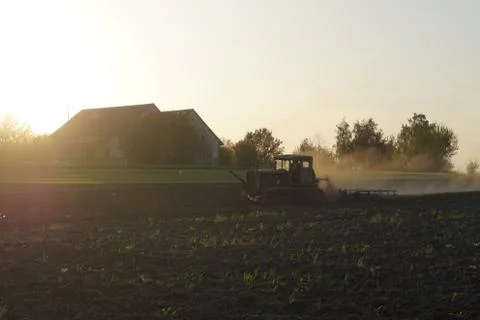 The tractor processes the field Stock Photos