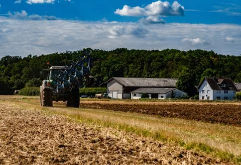 The tractor processing the field returns to the farm Stock Photos