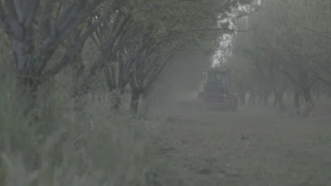 Tractor pulling away in a field in the distance Stockbeeldmateriaal 251841625