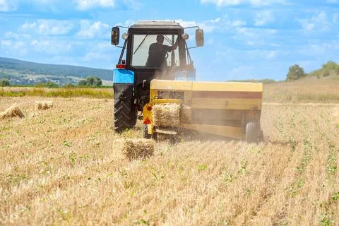 Tractor Pulling Baler to Make Fresh Hay Bales Stock Photos