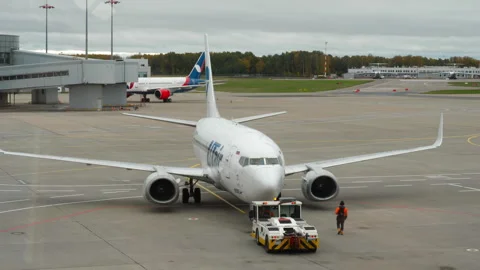 Tractor pulling Boeing 737 of UTair Stock Footage 281520188